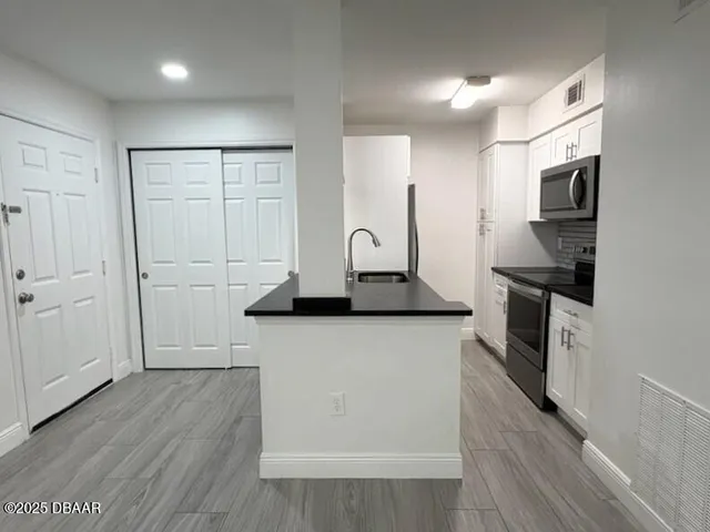 a kitchen with stainless steel appliances a refrigerator and a stove top oven