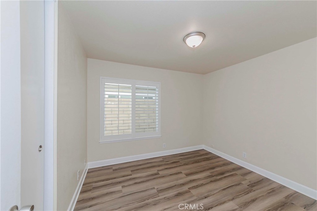 17502 De Oro Court Cerritos, CA 90703 - Photo 16 of 24 a view of an empty room with wooden floor and a window