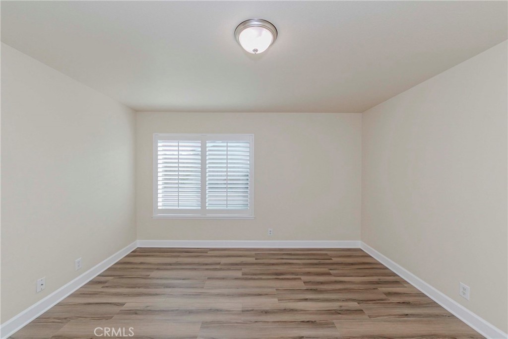 17502 De Oro Court Cerritos, CA 90703 - Photo 17 of 24 a view of an empty room with wooden floor and a window