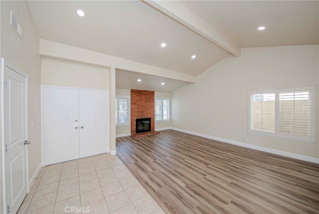 17502 De Oro Court Cerritos, CA 90703 - Photo 3 of 24 an empty room with wooden floor and a fireplace