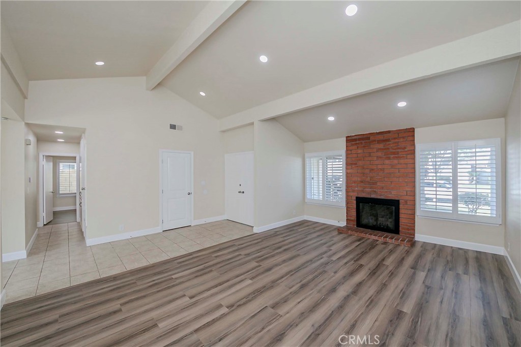 17502 De Oro Court Cerritos, CA 90703 - Photo 5 of 24 an empty room with wooden floor fireplace and windows
