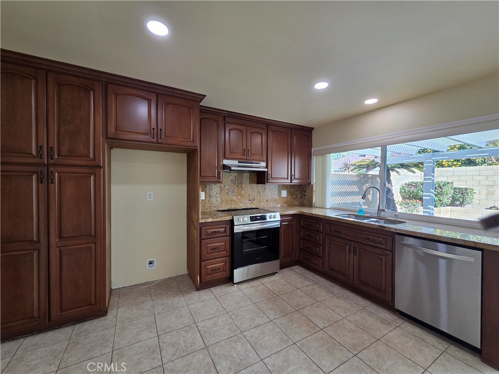 17502 De Oro Court Cerritos, CA 90703 - Photo 6 of 24 a large kitchen with stainless steel appliances granite countertop a refrigerator and a sink
