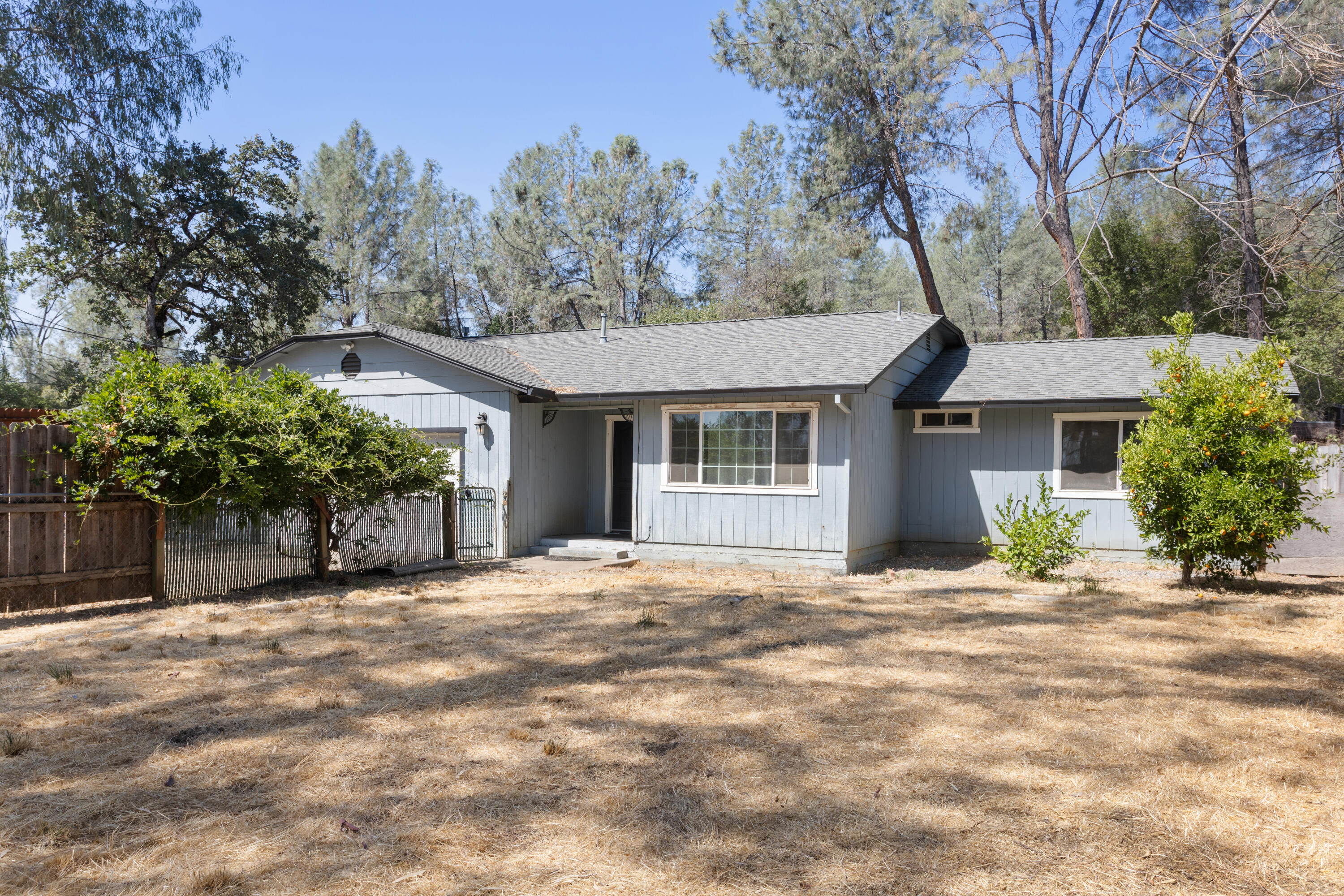 12656 Shalon Drive Redding, CA 96003 - Photo 1 of 21 a front view of a house with a garden and trees