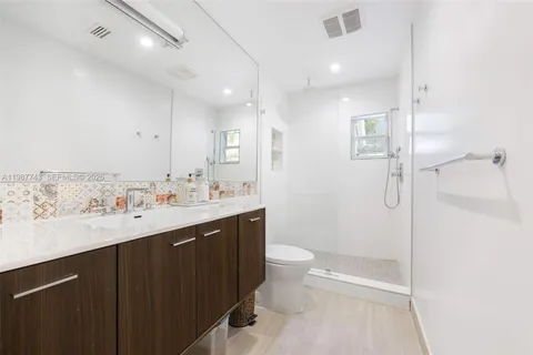 a bathroom with a sink a toilet and shower