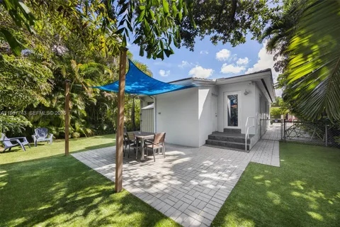 a view of a patio with table and chairs potted plants and a large tree