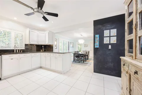 a kitchen with granite countertop cabinets a dining table and chairs