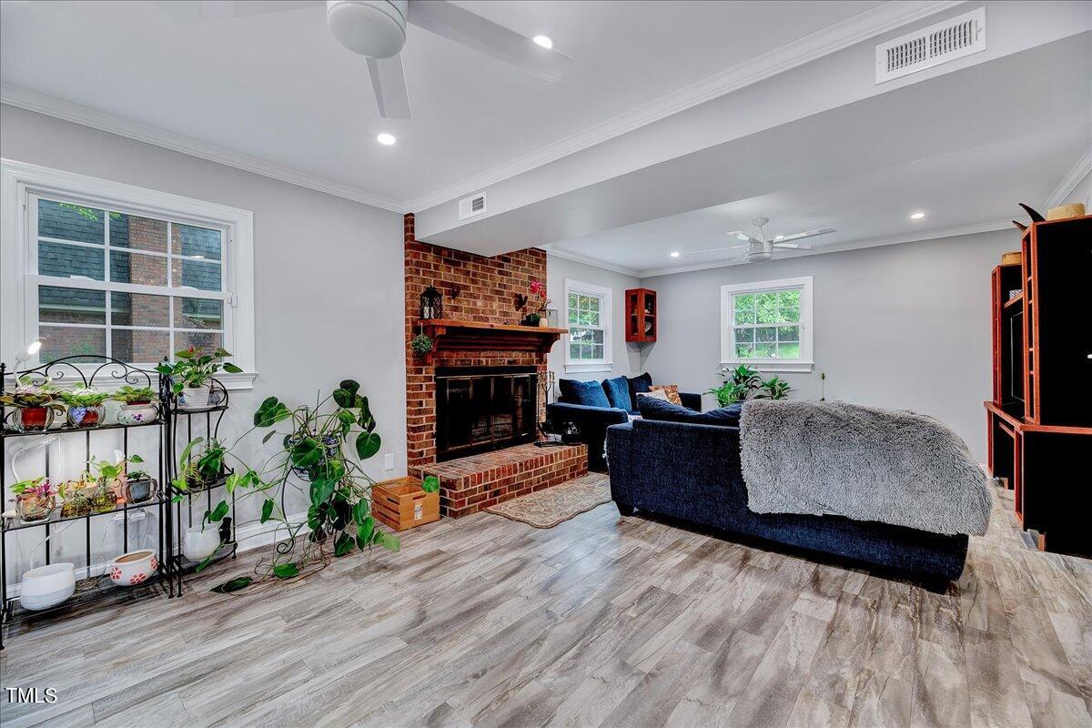 4209 Waterbury Road Raleigh, NC 27604 - Photo 17 of 30 a living room with furniture a flat screen tv and a fireplace