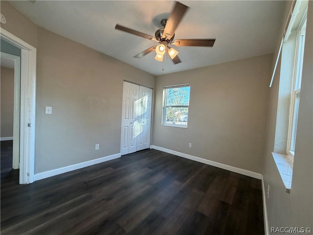 405 Copperfield Road Spring Hill, FL 34606 - Photo 18 of 25 an empty room with wooden floor fan and windows