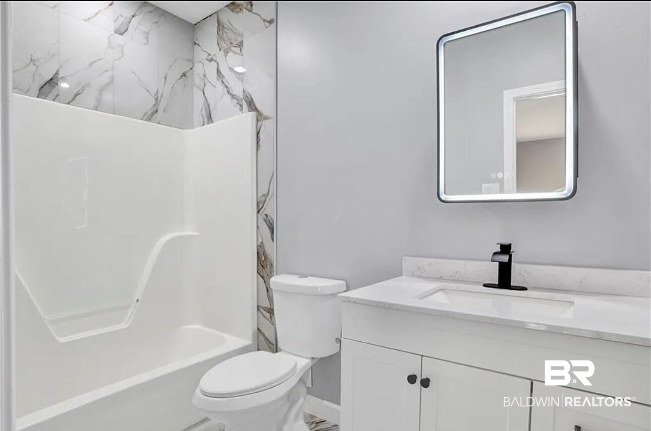 632 Ridgewood Drive Daphne, AL 36526 - Photo 27 of 36 Full bathroom with vanity, toilet, and shower combination