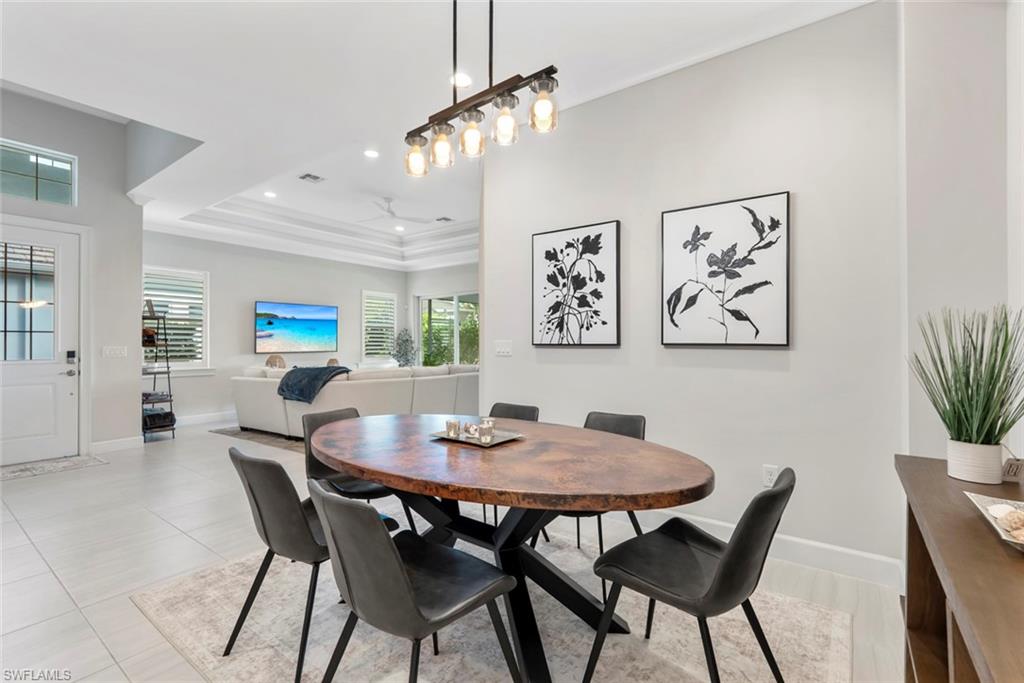 5716 Highbourne Drive Naples, FL 34113 - Photo 11 of 36 a view of a dining room with furniture and wooden floor