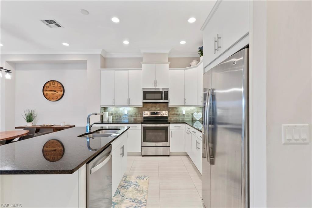 5716 Highbourne Drive Naples, FL 34113 - Photo 13 of 36 a kitchen with a sink stainless steel appliances and cabinets