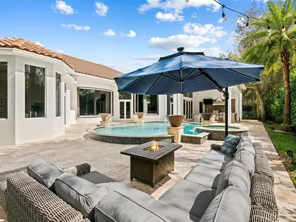 a view of a house with backyard sitting area and swimming pool