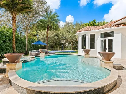 a view of a swimming pool with a yard and trees