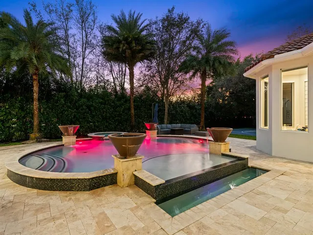 a spacious bedroom with a large bed and a chandelier