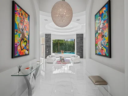 a living room with furniture a floor to ceiling window and a flat screen tv