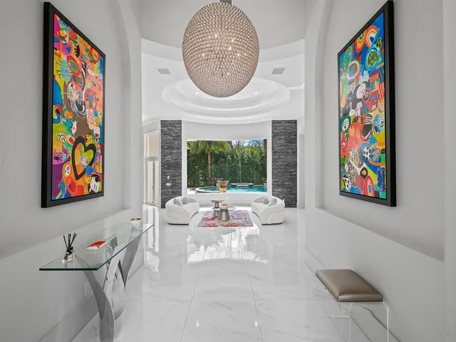 a living room with furniture a floor to ceiling window and a flat screen tv