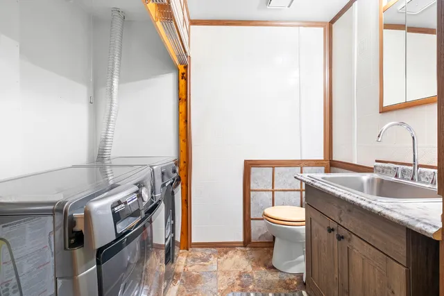 a bathroom with a granite countertop sink toilet and mirror