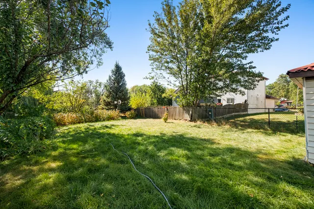 a backyard of a house with lots of green space and fountain