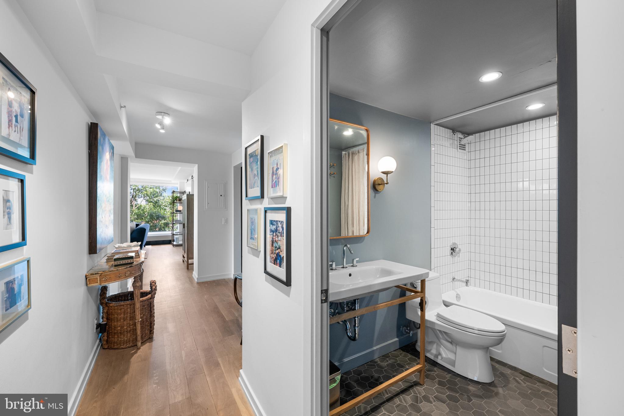 1101 3rd Street Southwest, Unit 315 Washington, DC 20024 - Photo 28 of 38 a bathroom with a toilet sink a mirror and shower