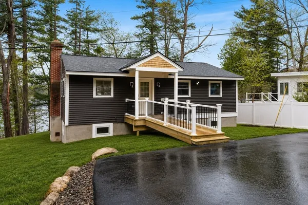 a view of a house with a yard and sitting area