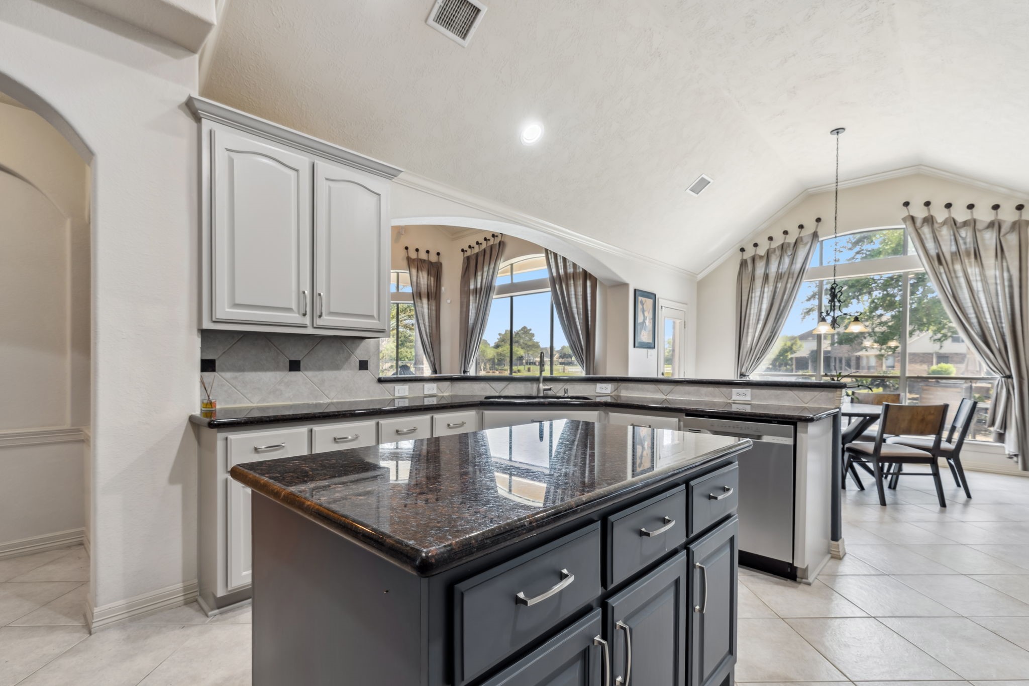 8411 Middle Canyon Road Katy, TX 77494 - Photo 26 of 49 a kitchen with granite countertop a stove a sink a dining table and chairs