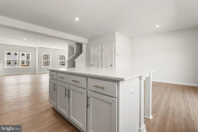 a kitchen with granite countertop white cabinets and wooden floor