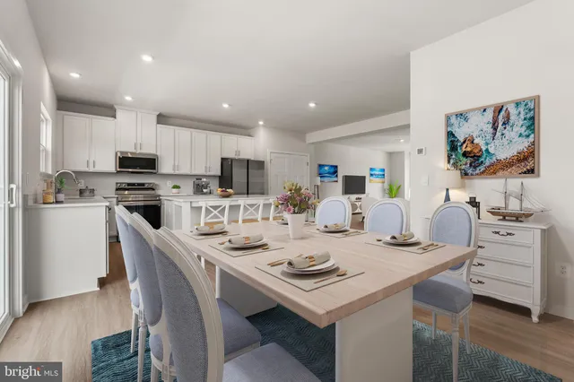 a kitchen with a sink a stove a kitchen island and chairs with wooden floor