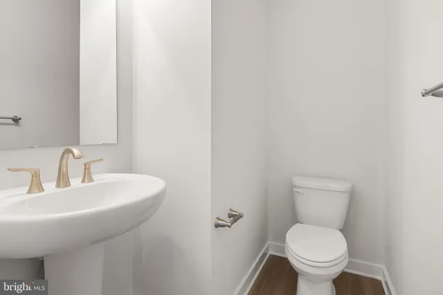 a bathroom with a toilet a sink and mirror