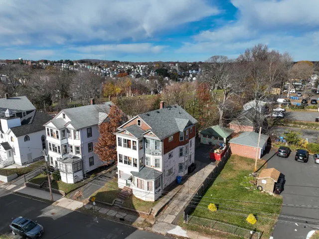 an aerial view of multiple houses with a yard