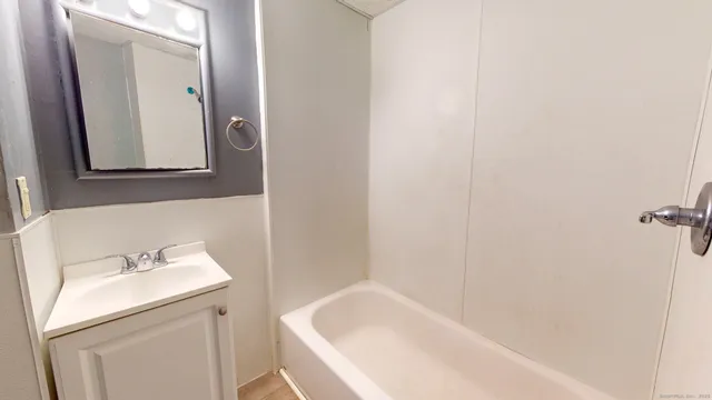 a bathroom with a sink and mirror with toilet