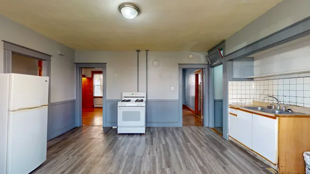 a kitchen with a refrigerator and a stove top oven