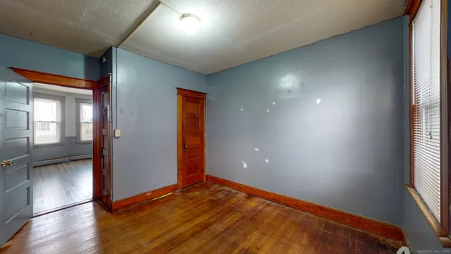 an empty room with wooden floor and windows