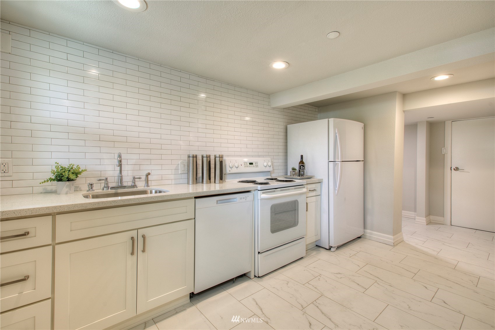 12222 Military Road South Seattle, WA 98168 - Photo 22 of 33 a kitchen with white cabinets and white appliances