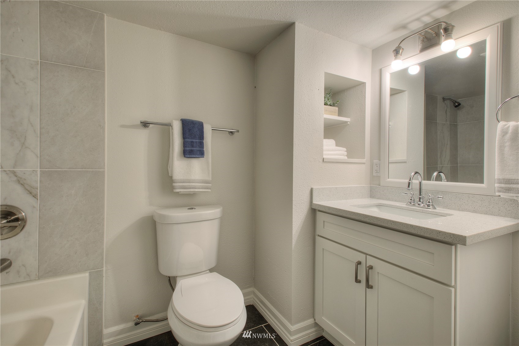 12222 Military Road South Seattle, WA 98168 - Photo 28 of 33 a bathroom with a granite countertop toilet a sink and a mirror