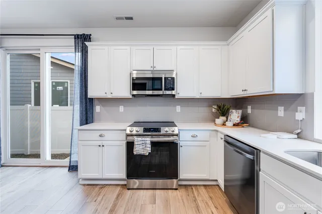 a kitchen with a stove a sink and a microwave