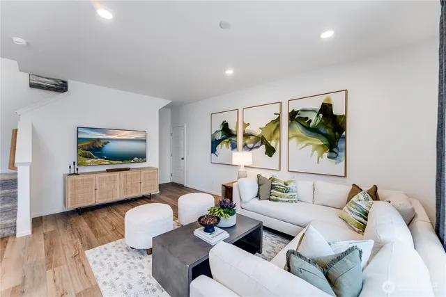 a living room with furniture and a wooden floor