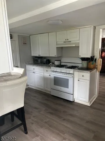a kitchen with stainless steel appliances white cabinets a sink and a stove