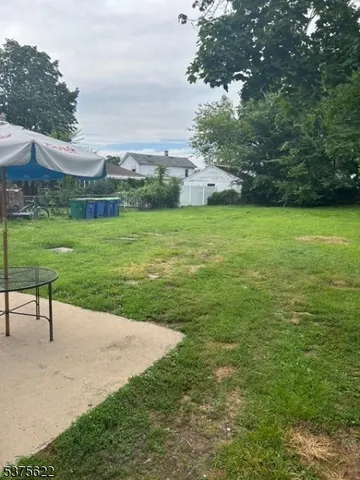 a view of a garden with lawn chairs and a large tree