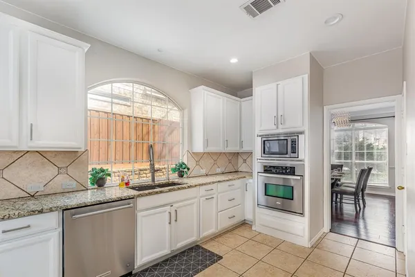 a kitchen with a white cabinets and window