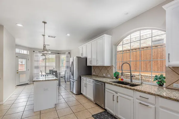 a kitchen with stainless steel appliances a refrigerator sink and cabinets