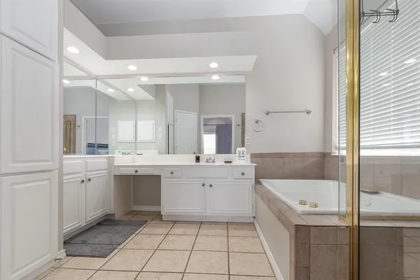 a bathroom with a tub sink and mirror