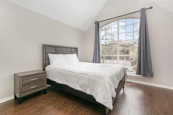 a large bed sitting in a bedroom next to a window