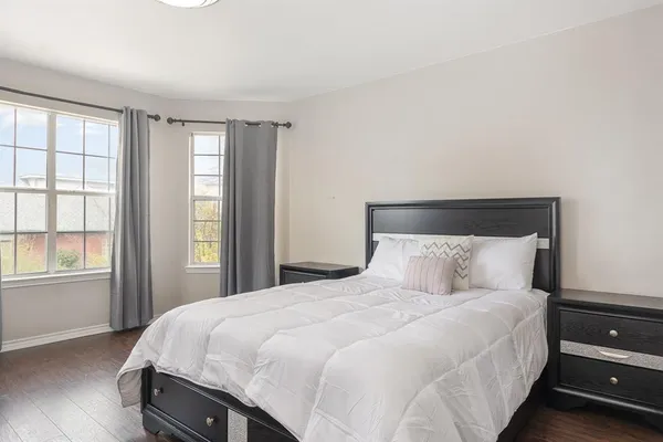 a large bed sitting in a bedroom next to a window