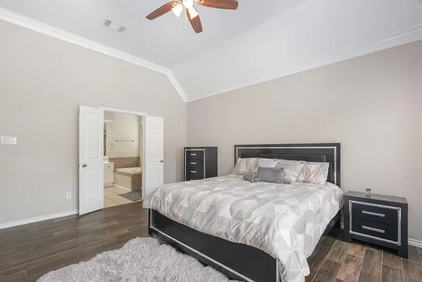 a large bed sitting in a bedroom and chandelier