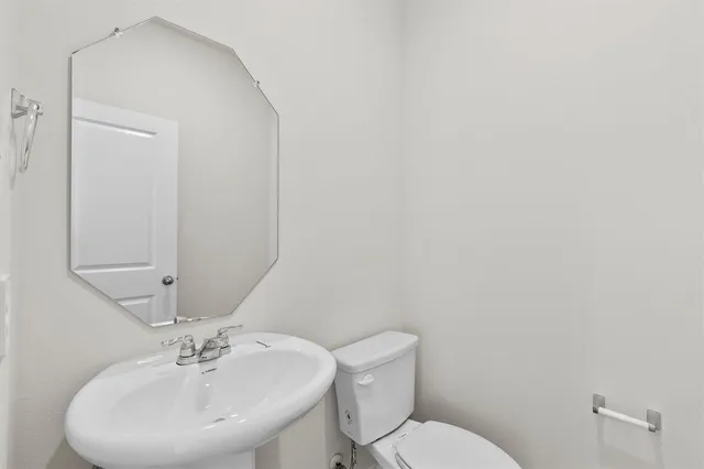 a bathroom with a sink mirror and toilet