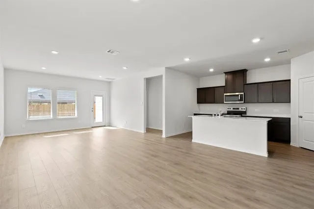 a large kitchen with stainless steel appliances kitchen island a large counter top and a stove top oven