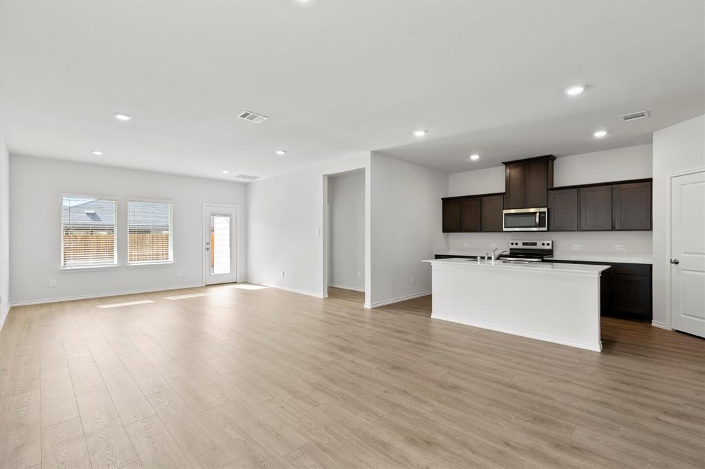 3416 Rendezvous Way Sherman, TX 75090 - Photo 3 of 24 a large kitchen with stainless steel appliances kitchen island a large counter top and a stove top oven
