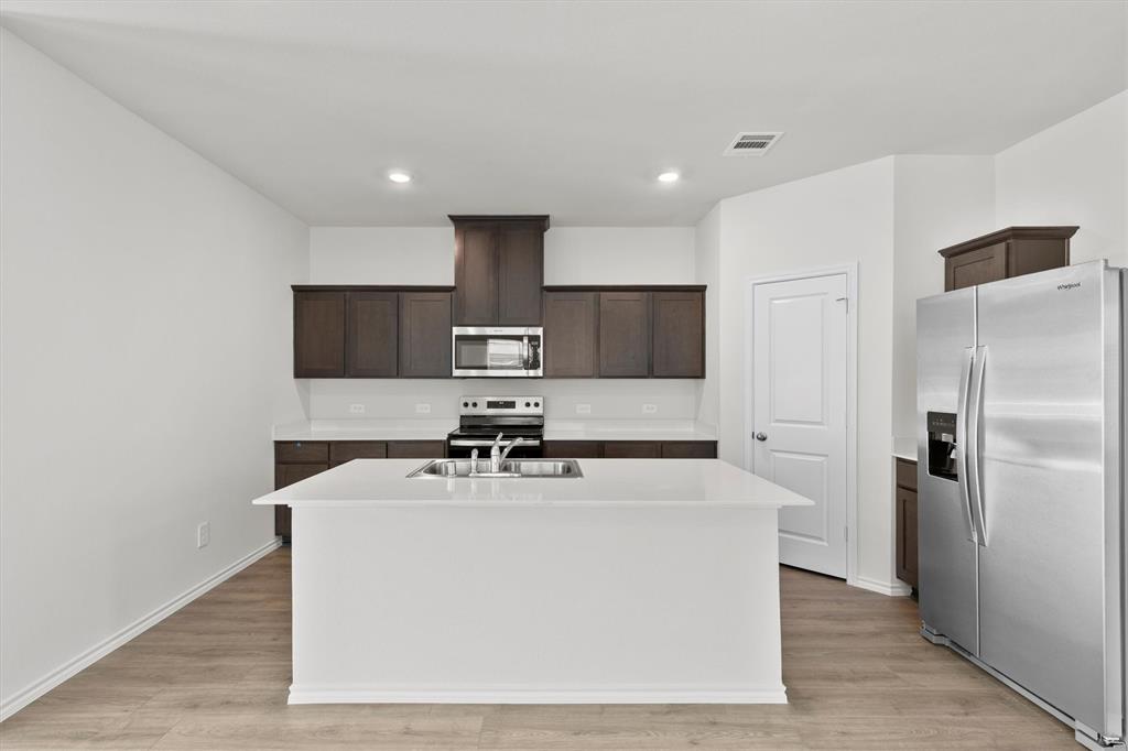 3416 Rendezvous Way Sherman, TX 75090 - Photo 4 of 24 a white kitchen with a sink a refrigerator and cabinets