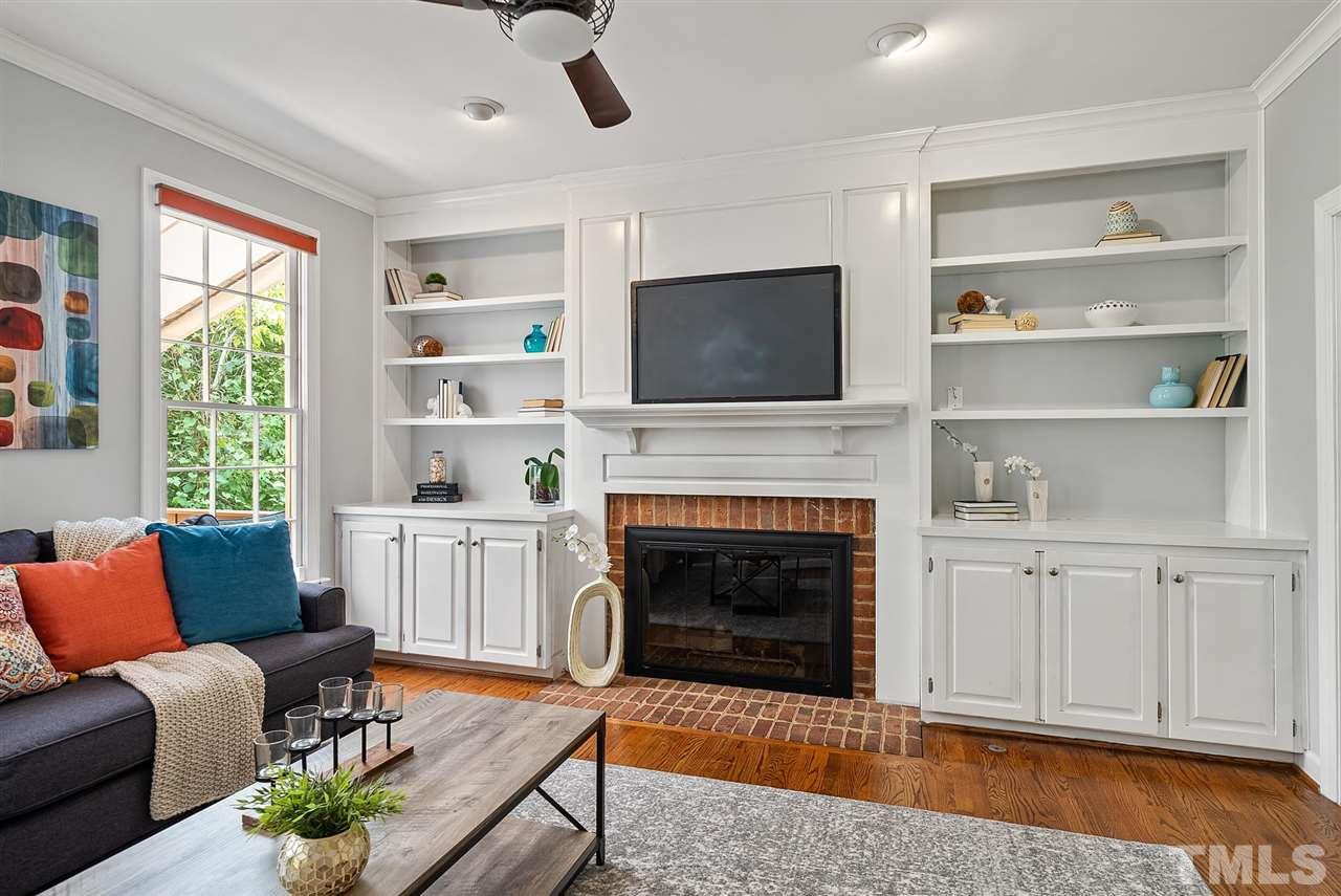 1209 Weldon Place Raleigh, NC 27608 - Photo 5 of 30 a living room with furniture a flat screen tv and a fireplace