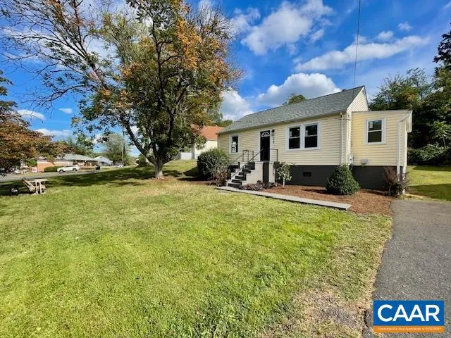 a view of a house with backyard and sitting area